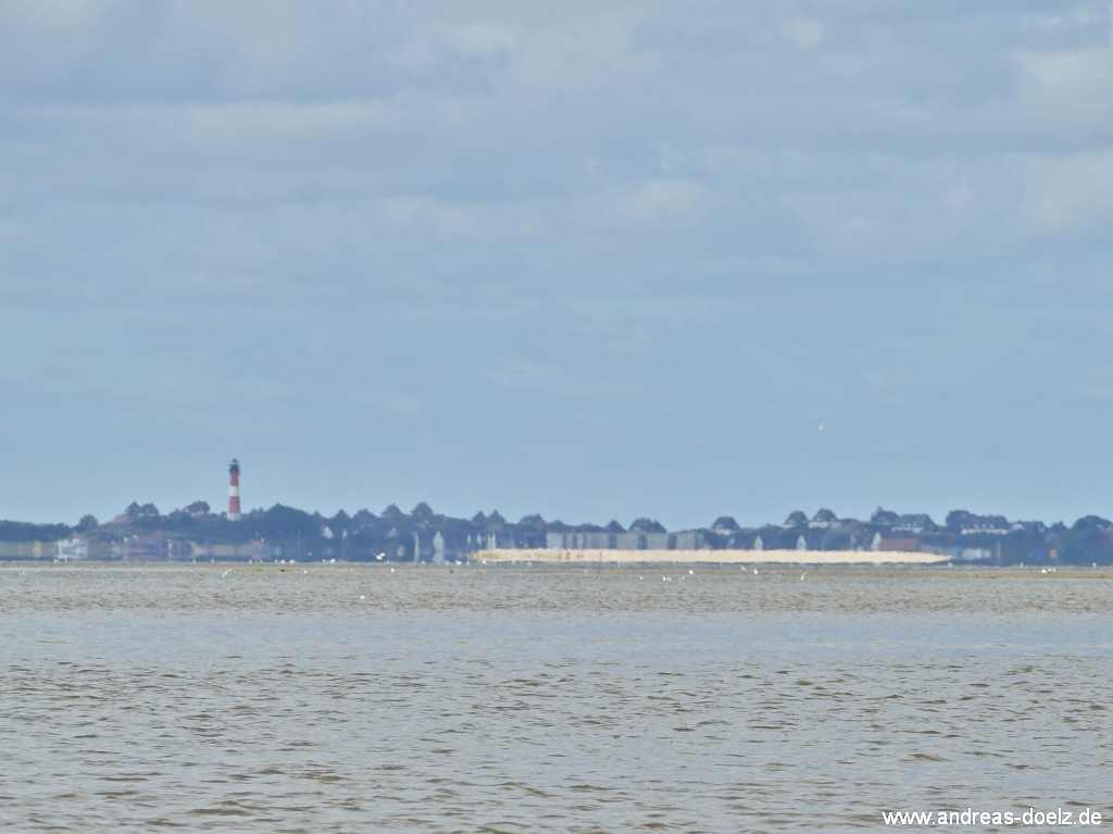 Wattwanderung zur Kormoraninsel von Amrum aus:  Auf dem Weg nach F&ouml;hr &uuml;ber das Watt ist im R&uuml;ckblick eine interessante Luftspiegelung zu sehen: Die Kormoraninsel scheint als braunes Band vor dem Hintergrund zu schweben.