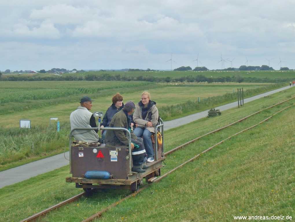Eine Lore verl&auml;sst den Hallig-Bahnhof und &uuml;berquert den Deich bei Dageb&uuml;ll