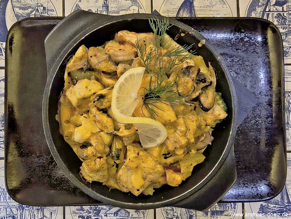 Fischpfanne mit Fischw&uuml;rfeln, Meeresfr&uuml;chten, Garnelen/Muscheln, Butterreis und Hummersauce im Hotel-Restaurant Friedrichs in Nebel