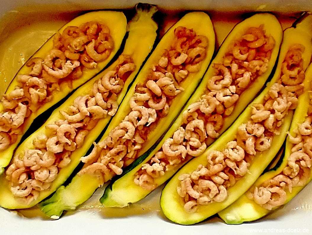 FFrische Nordsee-Krabben in halbierten Zucchini-Scheiben zum &Uuml;berbacken mit K&auml;se in einer Auflauf-Form